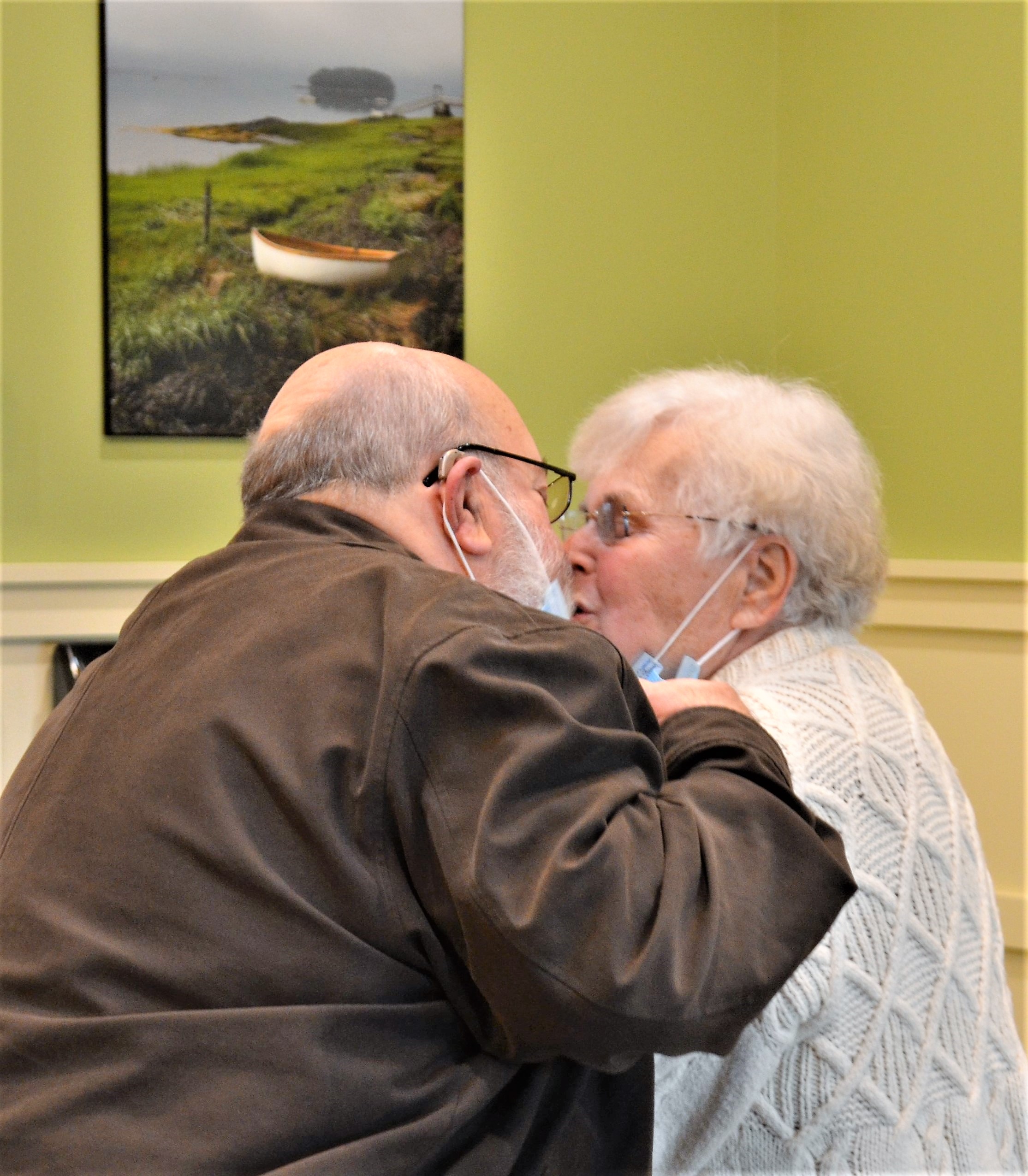 caregiver and his spouse kissing